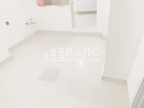Prazna svetla prostorija sa belim pločicama na podu. - image 11