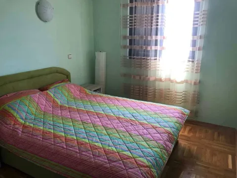 Spavaća soba sa bračnim krevetom i prozorom sa zavjesama. - image 9