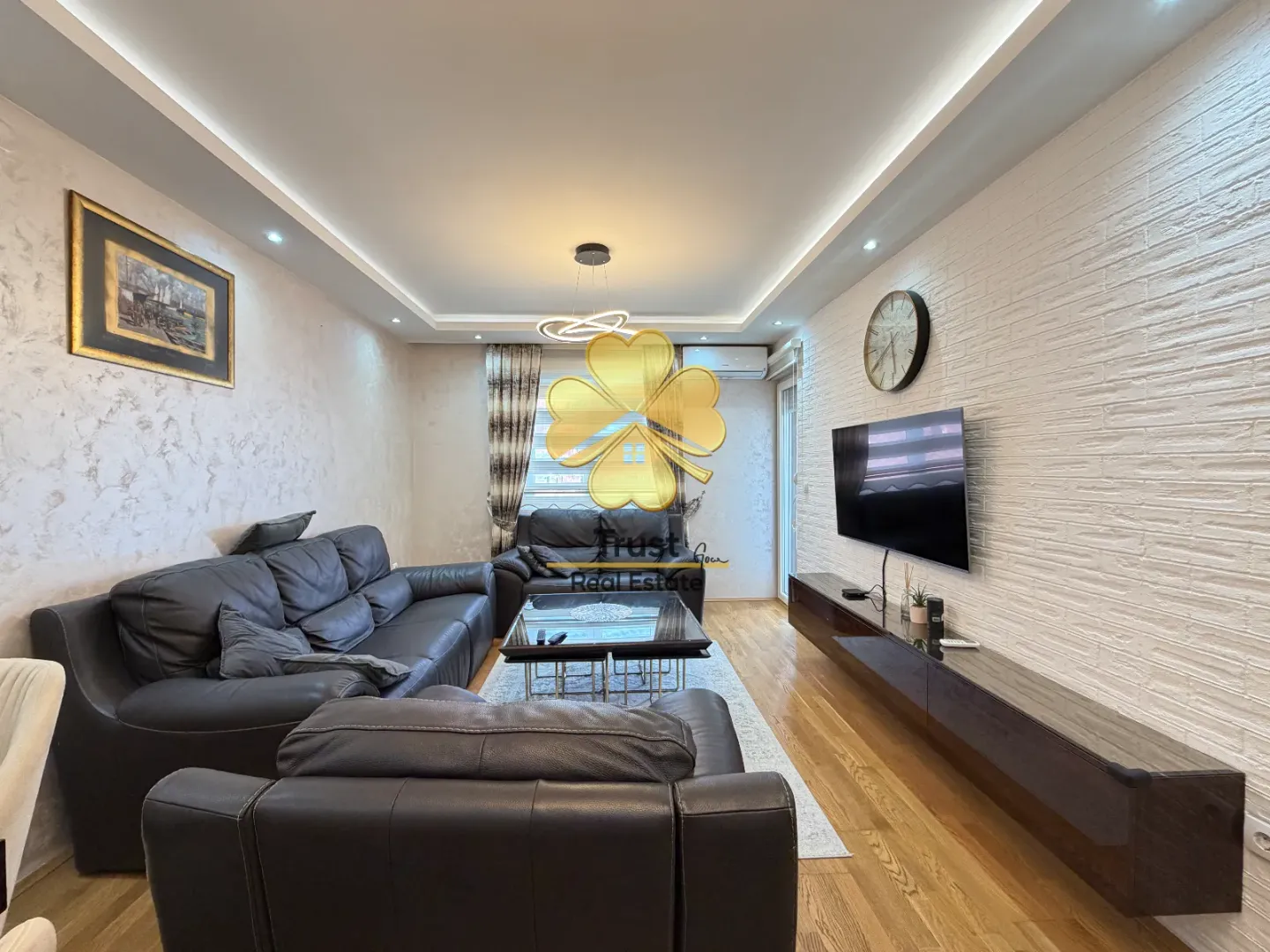 Spacious living room with a seating set and a TV unit.
