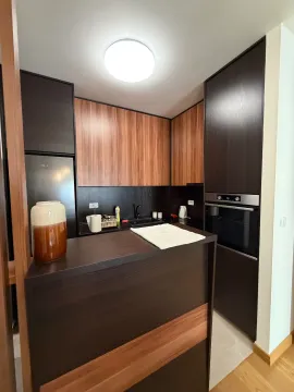 Modern kitchen with dark elements and wooden details. - image 4