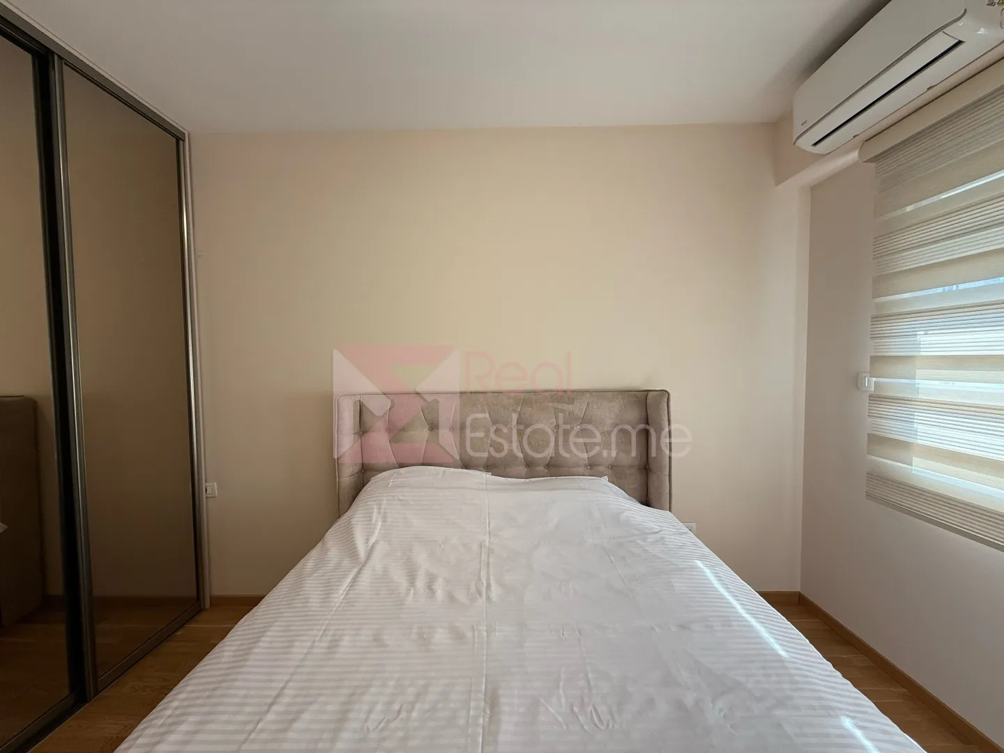 Furnished bedroom with a double bed, wardrobe, and air conditioning.