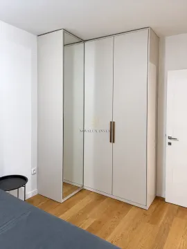Bedroom with a built-in mirrored wardrobe and wooden flooring. - image 4