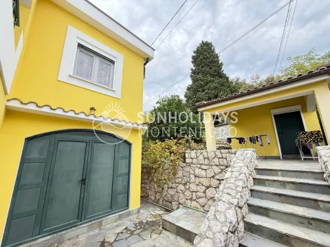Eksterijer žute kuće sa kamenim stepeništem i popločanim dvorištem. - image 4