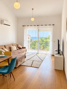 Living room with a sofa, dining table, and sea view. - image 14