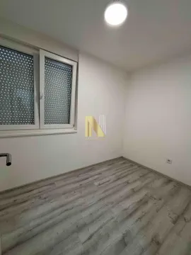 Prazna neopremljena soba sa laminatom i prozorom sa roletnama. - image 4