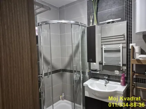 Kupatilo opremljeno tuš kabinom, umivaonikom i ogledalom sa ormarićem. - image 11