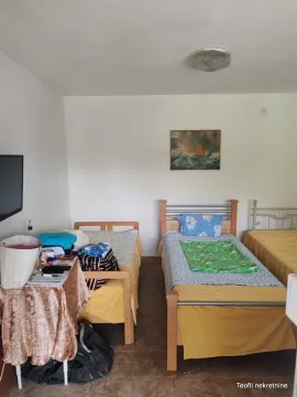 Spavaća soba sa tri kreveta i slikom na zidu. - image 6