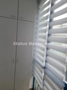 Beli ugradni ormar pored prozora sa roletnama. - image 4