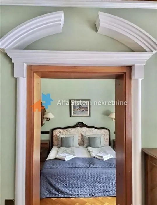 View through a decorated doorway into a bedroom with a double bed.