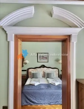 View through a decorated doorway into a bedroom with a double bed. - image 16