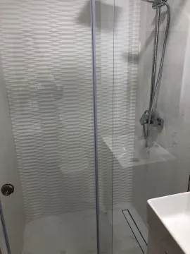 A modern shower cabin with glass doors in a bathroom. - image 26