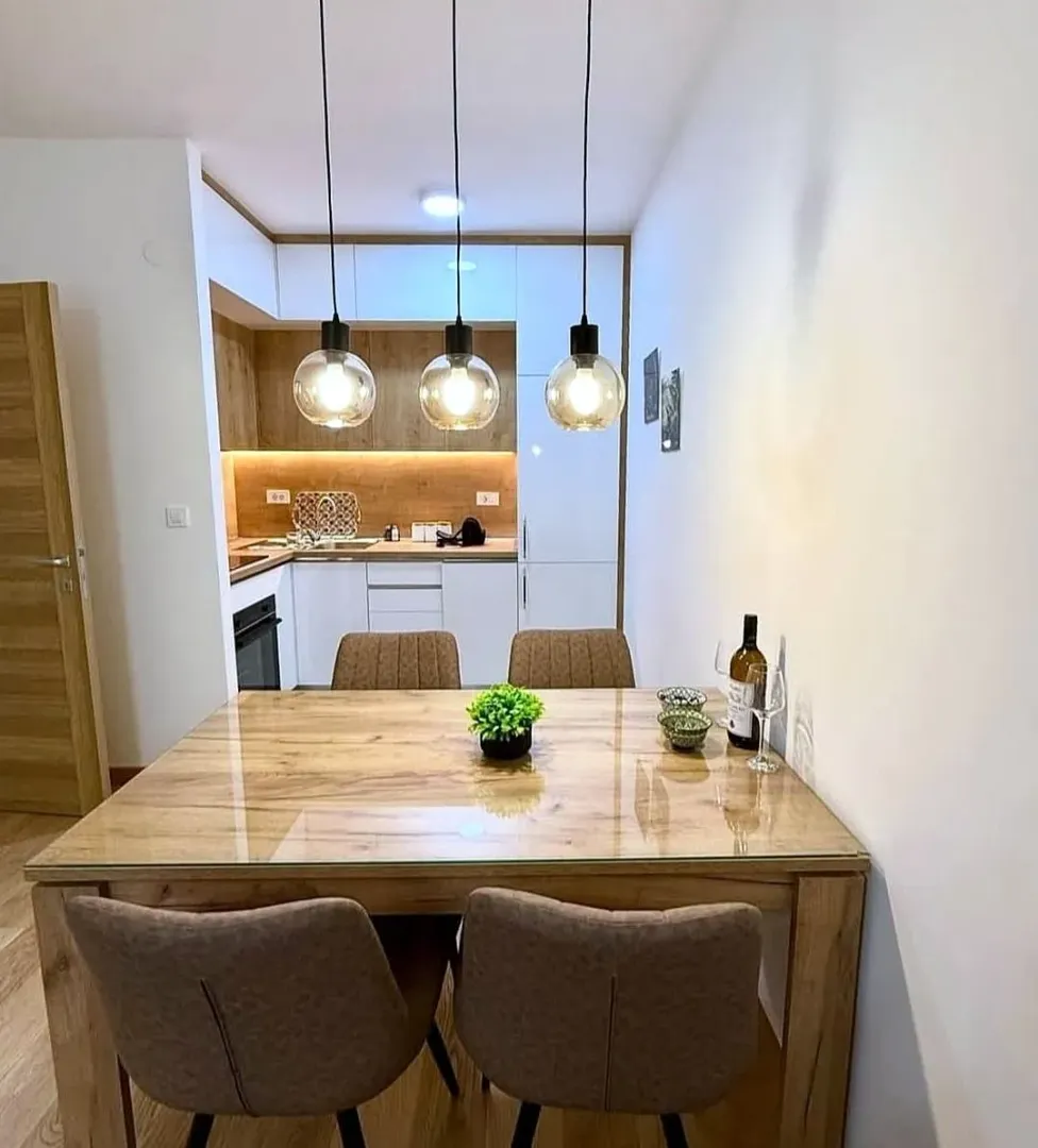 Dining area with a wooden table and chairs overlooking the kitchen.
