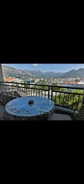 Terrace with outdoor seating and a view of the city and mountains. - image 5