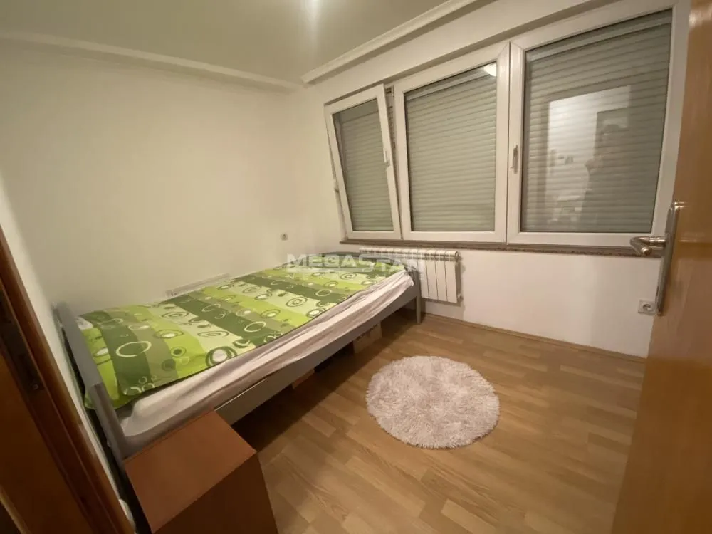 Small bedroom with a bed and a window.