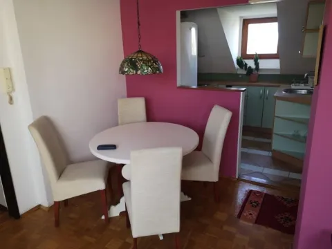 Dining area with a round table and chairs, overlooking the kitchen. - image 3