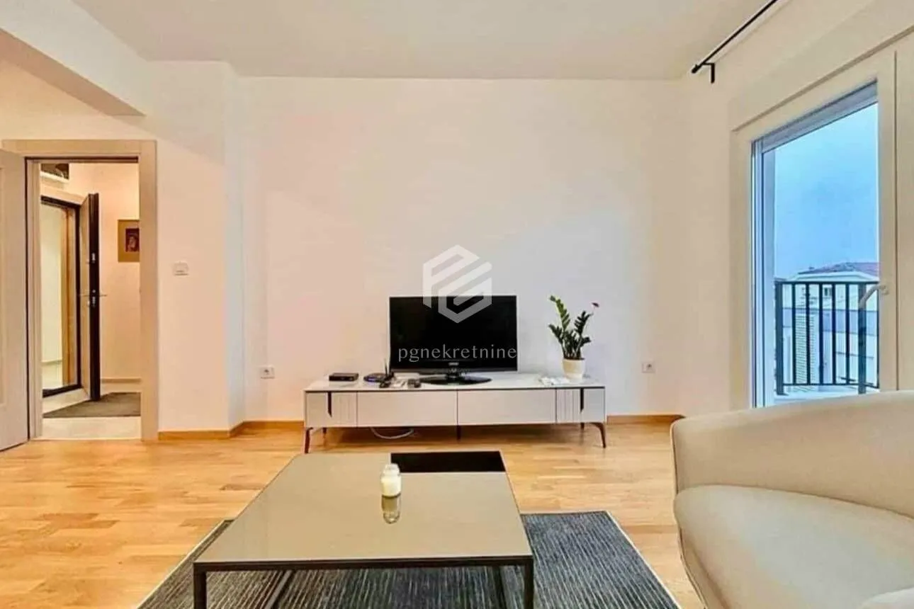 Living room with sofa, television, and access to the terrace.
