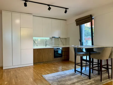 Modern kitchen with white and wooden elements and a dining table with chairs. - image 13