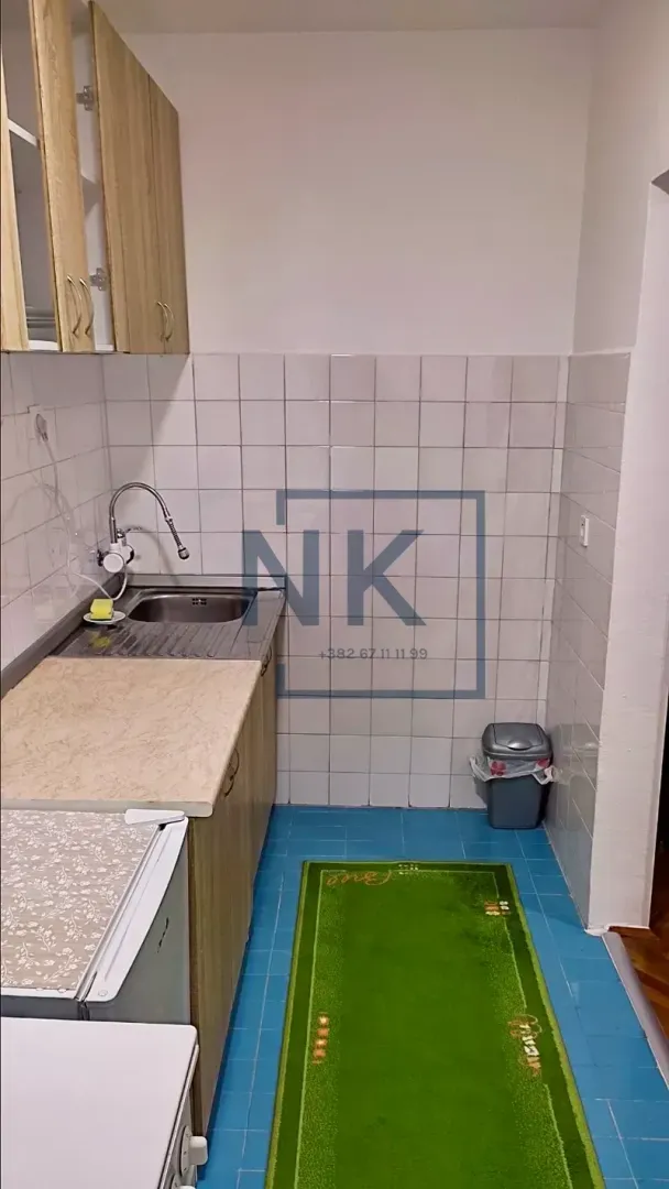 Small kitchen with a sink, cabinets, and wall tiles.