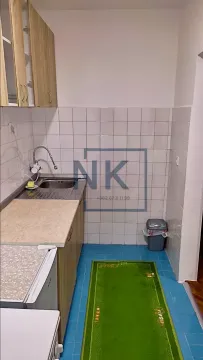 Small kitchen with a sink, cabinets, and wall tiles. - image 4