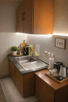 Manja drvena kuhinja sa sudoperom i radnom površinom. - image 9