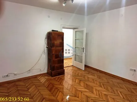 Empty room with wooden parquet flooring and a solid fuel stove. - image 11