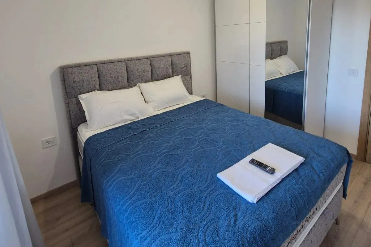 Furnished bedroom with a double bed and a wardrobe.