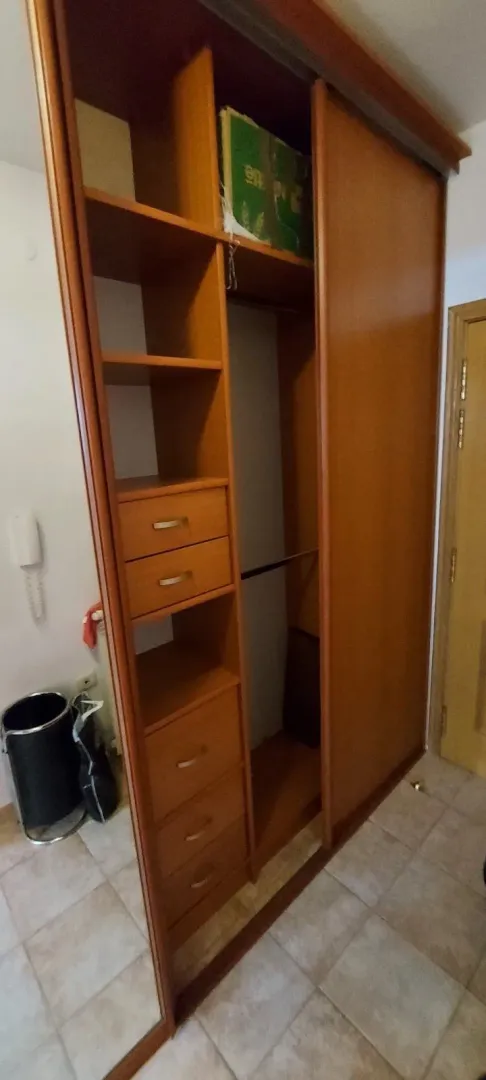 Veliki drveni ugradni ormar sa kliznim vratima.
