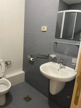 Kupatilo sa sivim pločicama, bijelim lavaboom i ogledalom. - image 6