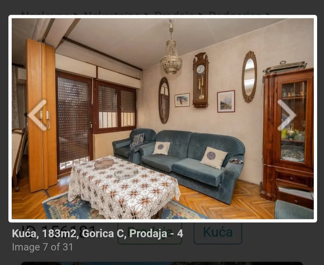 Dnevna soba sa garniturom, drvenim namještajem i detaljima na zidu.