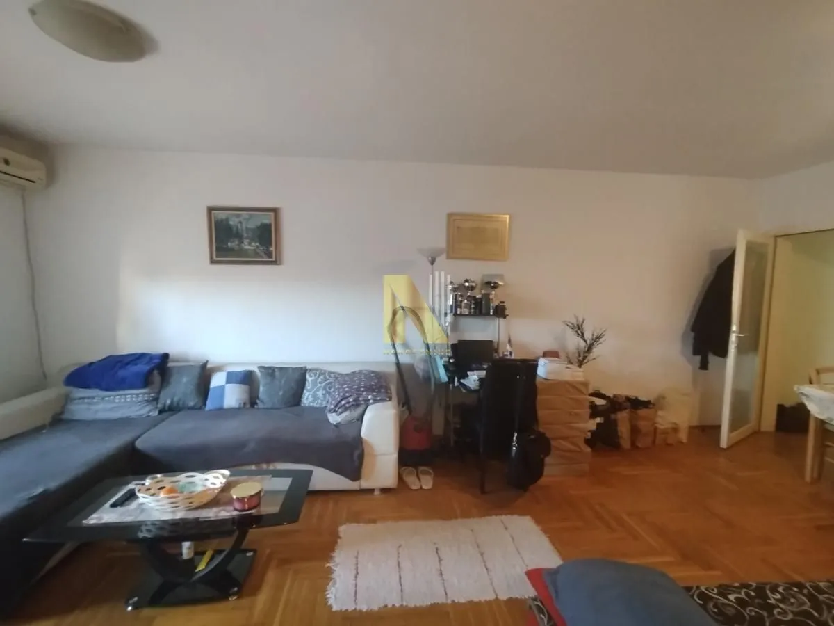 Dnevna soba sa garniturom i radnim kutkom.