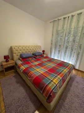 Spavaća soba sa bračnim krevetom, noćnim stočićima i prozorom sa zavjesama. - image 7