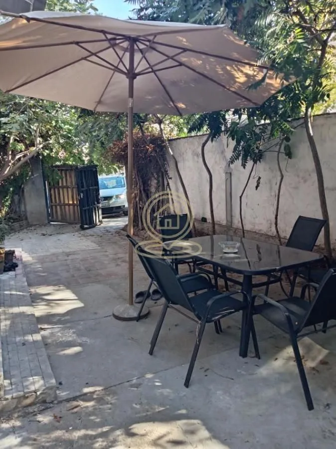 Yard with outdoor seating furniture and a parasol.