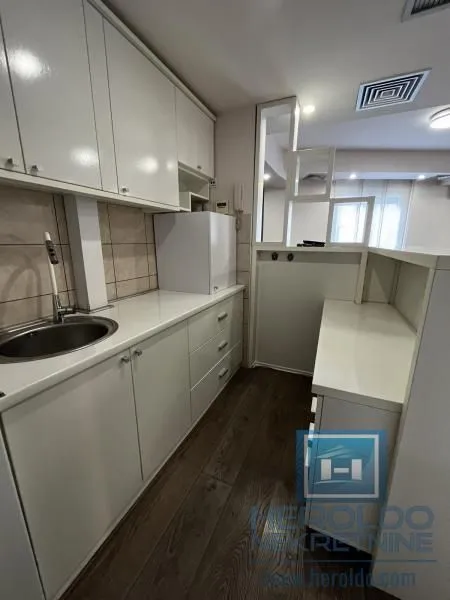 Small kitchen with white cabinetry and a sink.