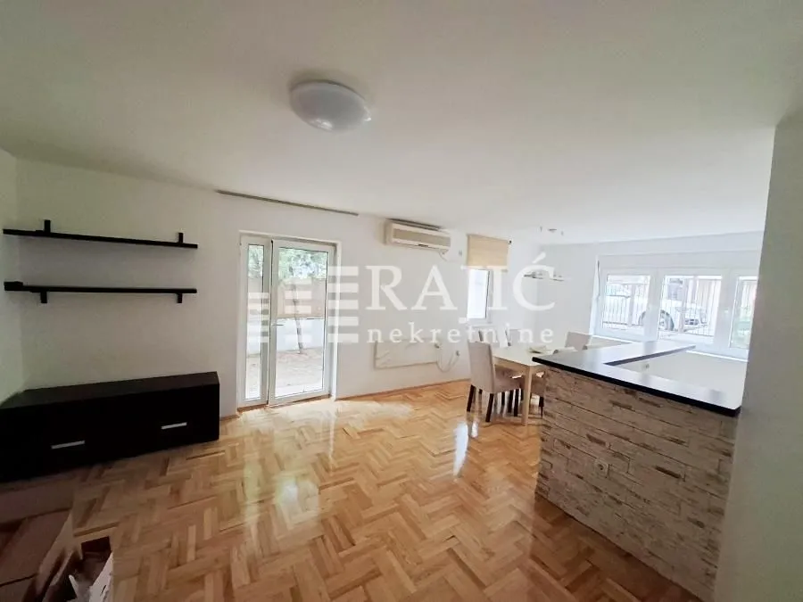 Spacious living room with a dining area and parquet flooring.