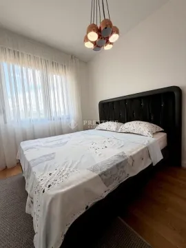 Furnished bedroom with a large double bed and a modern chandelier. - image 7