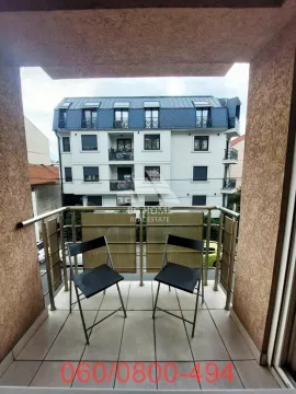 Manji natkriveni balkon sa metalnom ogradom i stolicama, sa pogledom na susednu zgradu. - image 10