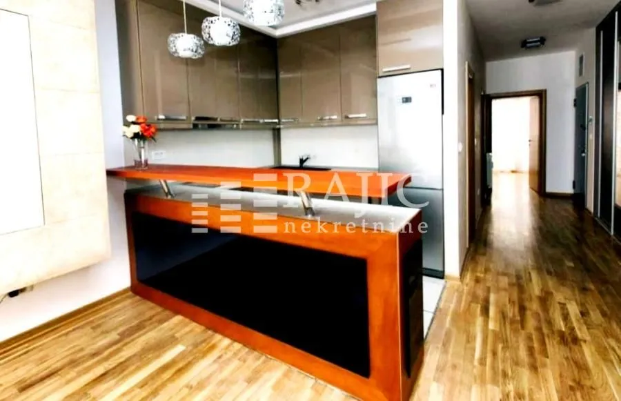 Modern kitchen with a bar counter and wooden elements.