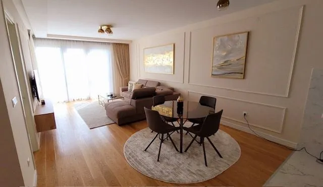 Living room with dining area, sofa set, and round table.