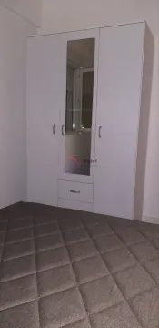 Bedroom with a large white wardrobe with a mirror and a double bed. - image 4