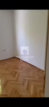 Prazna soba sa drvenim parketom i belim zidovima. - image 3