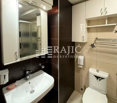 Smaller bathroom with a sink, toilet, and wall cabinets. - image 5