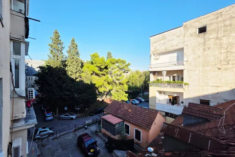 Pogled iz stana na okolne zgrade, drveće i parking. - image 4
