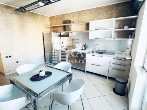 Modern kitchen with a dining table and white cabinets. - image 6
