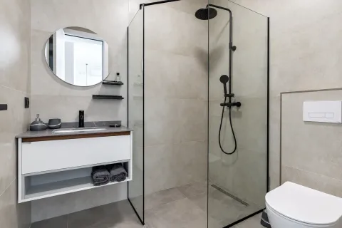 Moderne kupatilo sa tuš kabinom, umivaonikom i okruglim ogledalom. - image 12