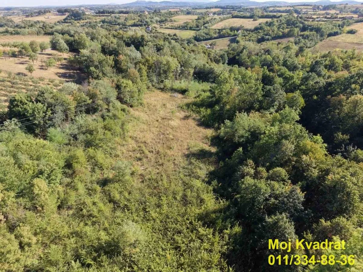 Pogled iz vazduha na zelenu površinu i okolni pejzaž.