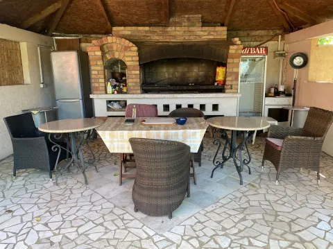 Covered outdoor dining area with a brick barbecue. - image 6