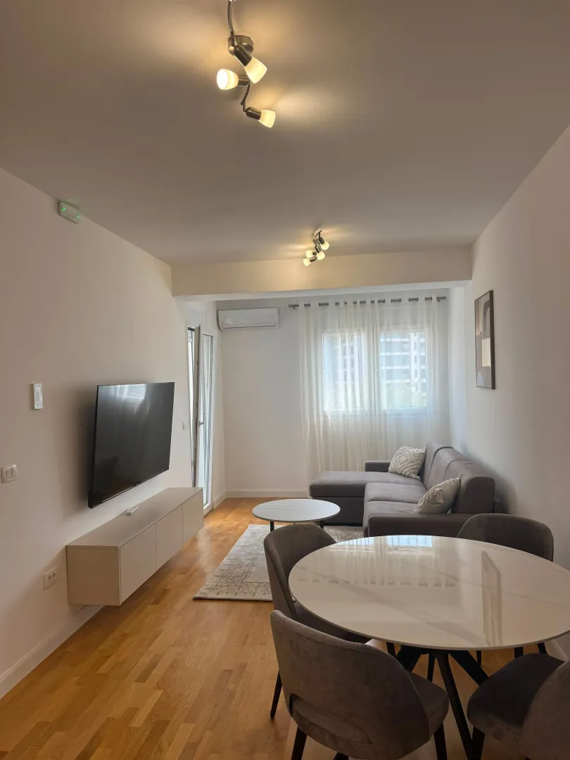 Living room with a sofa, TV, and dining table.