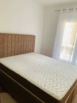 Bright bedroom with a double bed and a window covered with a white curtain. - image 10