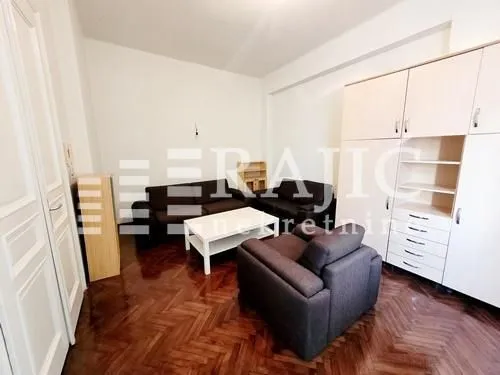 Furnished living room with a sofa set and parquet flooring.