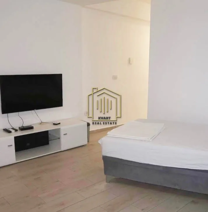 Small bedroom with a bed and a wall-mounted TV.